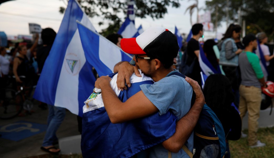 Men react during a memorial for journalist Angel Gahona in Managua